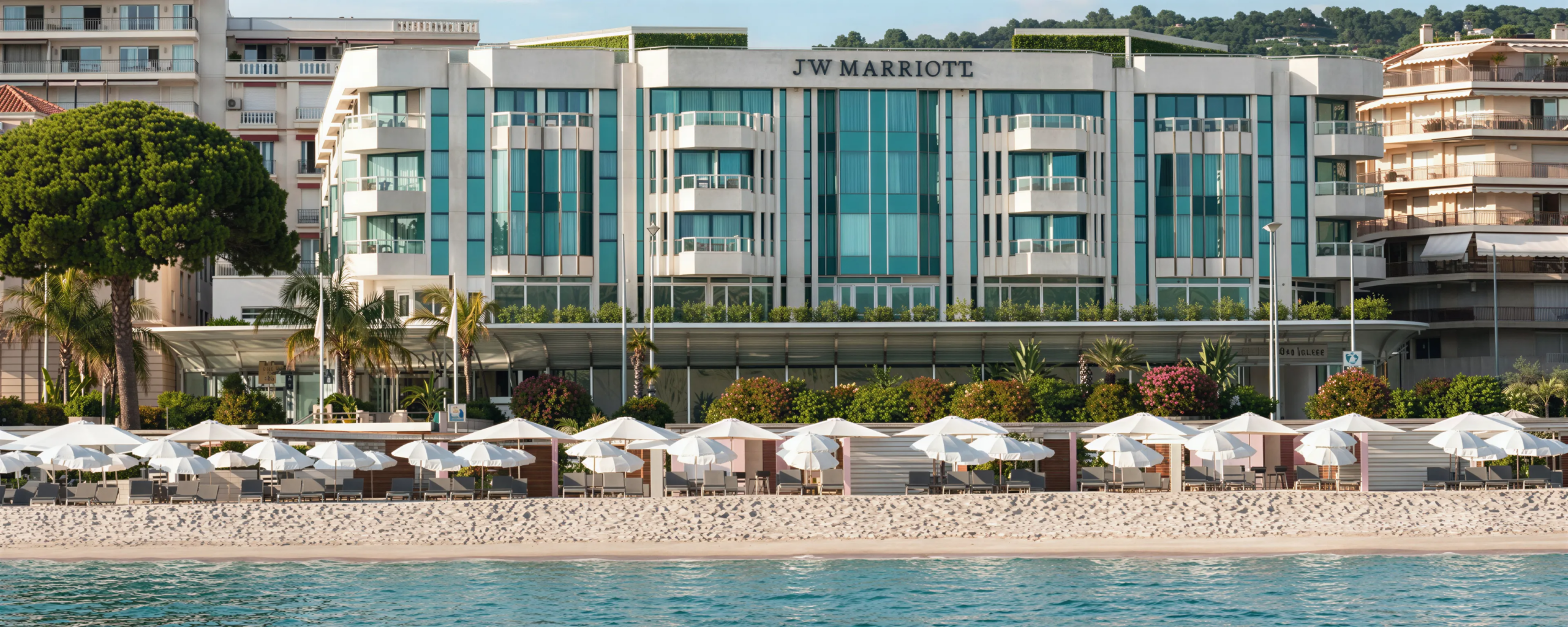Hall interna del JW Marriott Cannes con area lounge, reception e installazione luminosa sospesa